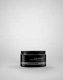 Black jar of clay pomade on a light gray background
