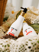 Two white bottles of ION-TO T FORTHE hair developer with a black pump and gold collar, styled on a white crochet blanket with coffee beans and a wicker basket background.